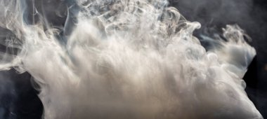 Güneşe karşı siyah bir arka planda beyaz kalın duman