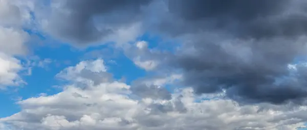 Blue sky with white and gray storm clouds