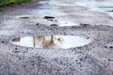 Yağmur sırasında asfaltta su birikintisi