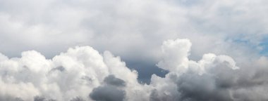 Gri gökyüzünde beyaz kabarık bulutlar
