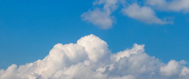 Mavi gökyüzünde beyaz kıvırcık bulutlar güneşli hava