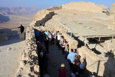 MASADA, ISR - 10 NOV 2022: İsrail 'in kutsal topraklarındaki Masada antik kalesini ziyaret eden turist grubu..