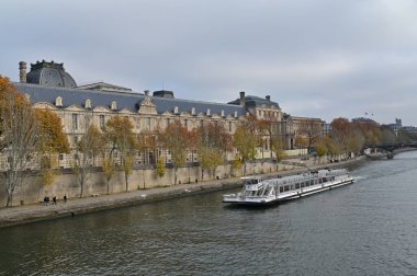 PARIS - NOV 30 2022: Paris, Fransa 'daki Louvre Müzesi' nin altında tekne turu. Bateaux Mouches, Seine nehri boyunca ziyaretçilere şehir manzarası sağlayan açık gezi tekneleri..