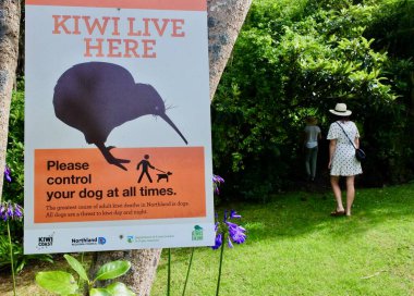 TAIPA, NZL - FEB 02 2023:People passing by Kiwi live here sign in a public park.Its estimated there are around 68,000 kiwis left and not managed kiwi populations continue to decline by 2% every year.