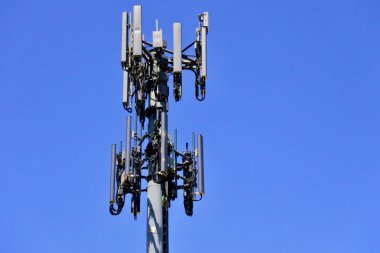 Large communication tower with 5G antenna  isolated on blue sky