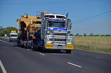 DUBBO, NSW - MAR 07 2023: Büyük bir kamyon bir maden makinası taşıyor. Madencilik sektörü 2019-20 yıllarında NSW ekonomisine 15 milyar dolar enjekte ederken, bölgedeki on binlerce kişiye iş imkanı sağlıyor.