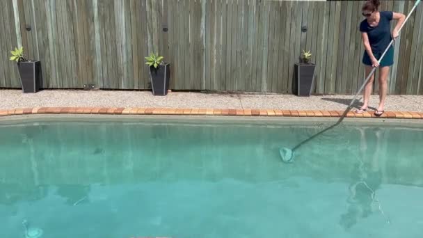 成年妇女 40岁女性 清扫自家后院的游泳池 — 图库视频影像