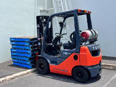 BRISBANE - 17 DEC 2024: TOYOTA LPG (Sıvılaştırılmış petrol gazı) Forklift endüstriyel giyim evinin önünde park halindedir. LP gazlı forkliftler temiz ve sessizdir, ancak vardiyalar arasında saatlerce şarj olmaya ihtiyaç duymazlar.