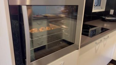 Yahudi kadın elleri Purim Yahudi bayramı için fırından yeni pişirilmiş Hamantaschen kurabiyeleri çıkarıyor.. 