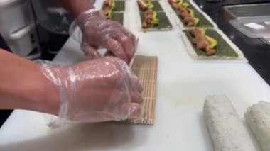 Japon suşi şefi mutfak tezgahında suşi hazırlıyor..