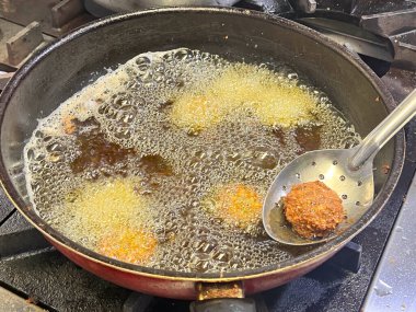 Kızartma tavasında kızarmış falafel topları. Falafel, Mısır kökenli, bol yağda kızartılmış bir top veya köfte şeklinde börek türüdür..