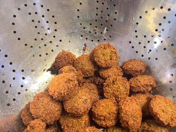 stock image Falafel balls in a sieve. Falafel is a deep-fried ball or patty-shaped fritter of Egyptian origin, in a kitchen.