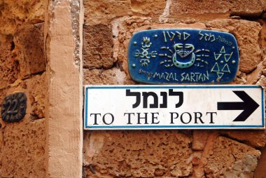 JAFFA, ISR - OCT 07 2007:To the port arrow sign and street sign with Zodiac horoscope signs in old city Jaffa.Jaffa streets have the names of the zodiac signs which is very unique and stands out. clipart