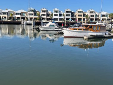 COOMERA, QLD - SEP 8 2024: Avustralya 'nın Queensland kentindeki Coomera Nehri' nin kıyısındaki Coomera Waters Marina lüks yerleşim bölgesinde yelkenli tekneleri demirledi.