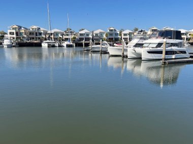 COOMERA, QLD - SEP 8 2024: Avustralya 'nın Queensland kentindeki Coomera Nehri' nin kıyısındaki Coomera Waters Marina lüks yerleşim bölgesinde yelkenli tekneleri demirledi.