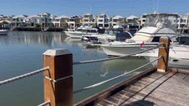 COOMERA, QLD - SEP 8 2024: Avustralya 'nın Queensland kentindeki Coomera Nehri' nin kıyısındaki Coomera Waters Marina lüks yerleşim bölgesinde demirli yelkenliler.