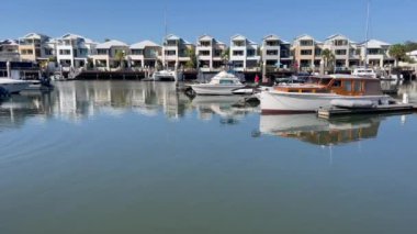 COOMERA, QLD - SEP 8 2024: Avustralya 'nın Queensland kentindeki Coomera Nehri' nin kıyısındaki Coomera Waters Marina lüks yerleşim bölgesinde demirli yelkenliler.