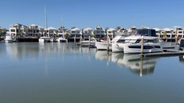 COOMERA, QLD - SEP 8 2024: Avustralya 'nın Queensland kentindeki Coomera Nehri' nin kıyısındaki Coomera Waters Marina lüks yerleşim bölgesinde demirli yelkenliler.
