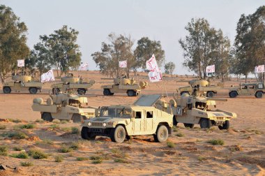 WESTERN NEGEV - JULY 11 2011:Caracal Battalion of the Israel Defense Forces driving a Humvee vehicles during training in the Negev desert, Israel. clipart