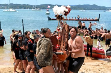 WAITANGI, NZL - Şubat 06 2025: Maori erkek ve kadın savaşçıları 1840 Waitangi Antlaşması 'nın yıldönümü münasebetiyle Yeni Zelanda' nın ulusal günü Waitangi Günü 'nde bir savaş kanosu taşıyorlar.