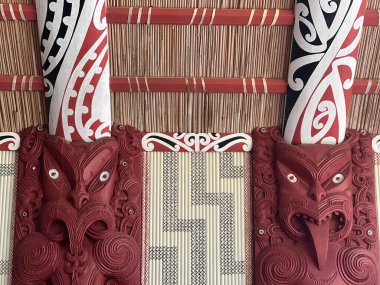 WAITANGI, NZL - Şubat 06 2025: Geleneksel Maori, Yeni Zelanda 'nın Northland kentindeki Te Whare Rnanga' da (oyulmuş Maori Toplantı Evi) ahşap oyma ile karşılaşıyor. Bina, sık sık yerel Maori kabilesinin atalarını simgeliyor.