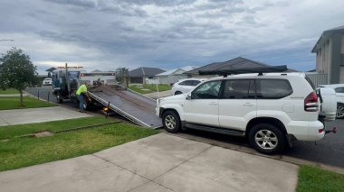PORT MACQuARIE, NSW - 27 Mayıs 2025: Bir Toyota Land Cruiser Prado aracını çeken kamyon sürücüsü. Avustralya 'da her yıl yaklaşık 1,2 milyon araba bozulur..