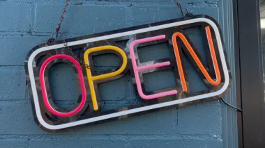 Tuğla duvarda renkli neon açık tabelası