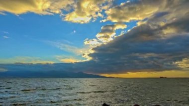 Ada sahilinden okyanus manzaralı Bulutlu Gün batımı görüntüsü.
