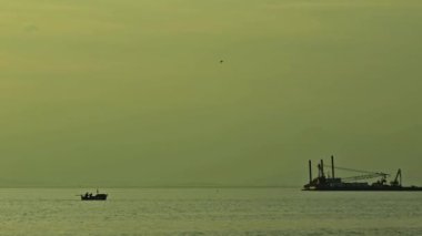 Sisli bir günde okyanusta balıkçı teknesi ve gemi temizleme deniz kiri..