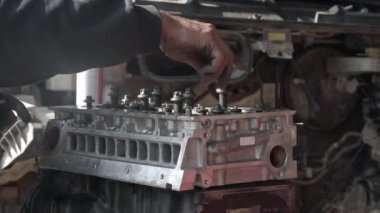 Hand Assembly Screws Engine Block In Auto Repair Shop Footage.