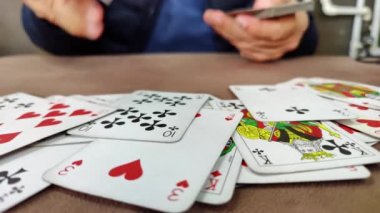 Throwing, or giving, playing cards on a Table surface, face up, showing numbers and cards suit.