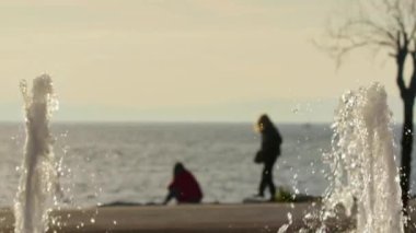 İki Kadın Arkadaş ve Sephia Kış Sahili Çeşmeli Su Damlaları Görüntüsü.
