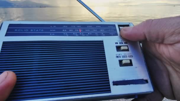 Ψάχνοντας Για Ραδιοφωνικά Κανάλια Tuning Pocket Radio Μια Συννεφιασμένη Μέρα — Αρχείο Βίντεο
