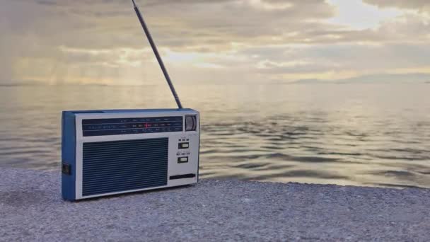 旧式复古手工袖珍收音机在一个多云的日子在海滩上的镜头 — 图库视频影像