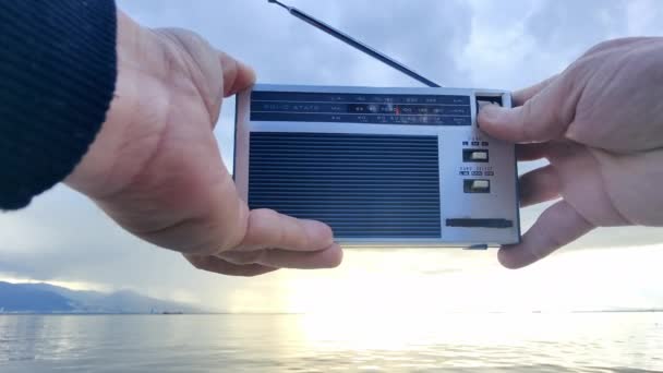 在多云的日子里 在海滩上寻找用袖珍收音机调音的无线信道 — 图库视频影像