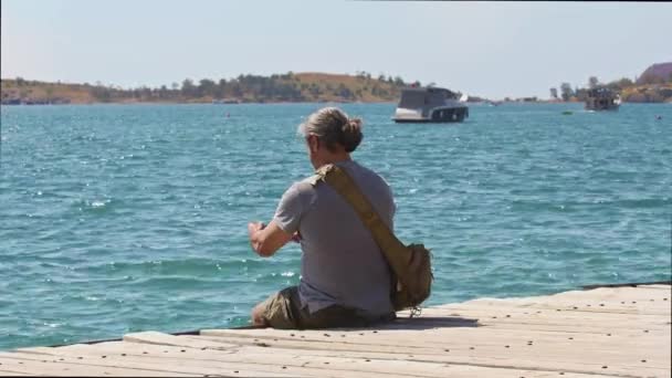 Traveler Man Przechwytywanie Ocean View Telefonu Komórkowego Siedzi Drewnianym Molo — Wideo stockowe
