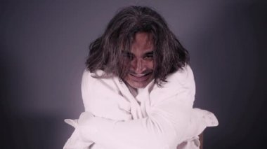 Deli gömleği giyen Psikopat Adam 'ın Çılgınca Hareketleri. Deli gömlekli Deli Adam 'ın Yakın Çekim Portresi.