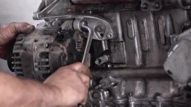 Alternatör şarj vidalarını sıkarak Tamir atölyesindeki Arızalı Eski Araba Motoru.