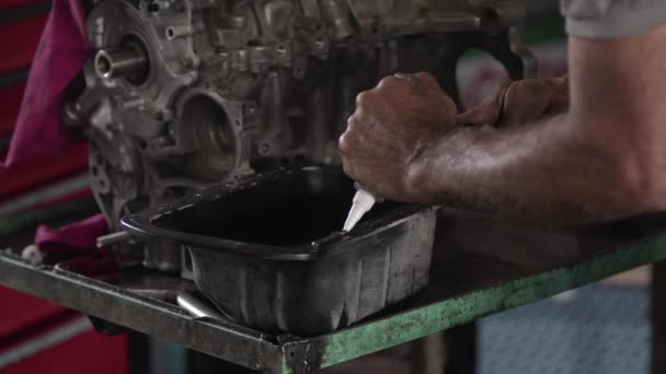 修理工場映像でシール液ガスケットで修理されている車のエンジンクランクケースカバー — ストック動画
