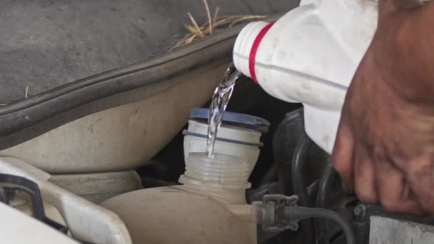 Einen Alten Automotor Mit Kühlwasser Aus Einem Kanister Füllen — Stockvideo