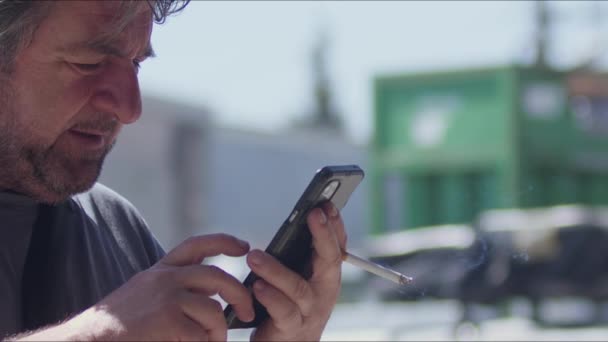 Hombre Mediana Edad Navegando Por Internet Teléfono Móvil Mientras Fuma — Vídeo de stock