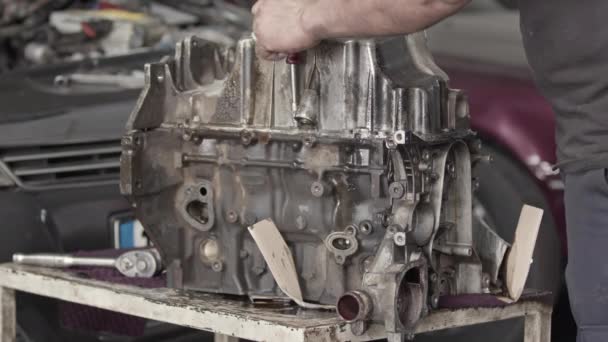 修理工場の工場のワークベンチ上の古い石油内部燃焼車エンジンの修理 — ストック動画