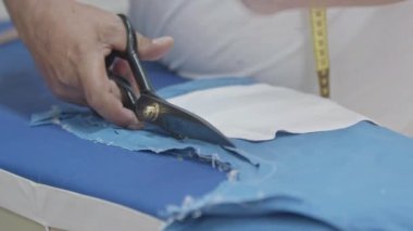 Terzi atölye çekiminde Kumaşı Makasla Kesiyor.