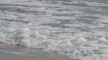 Okyanus kabaran köpüklü dalgalar sahile çarpıyor..