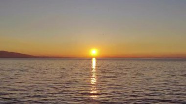 Deniz 'in Üzerinde Mükemmel Portakal Gün Batımı ve Su Görüntülerinde Parıltı.