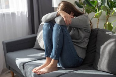 Bunalımlı, genç, esmer bir kadın evde yalnız başına ağlarken yorgun ve endişeli hissediyor zihinsel sağlık, yalnızlık ve izolasyon konseptinde depresyon yaşıyor. Psikoloji, yalnızlık ve insanlar
