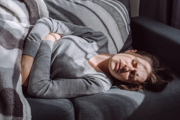 Ανθυγιεινή Γυναίκα Παλεύει Επώδυνο Πόνο Ξαπλωμένη Στον Καναπέ Στο Σπίτι — Φωτογραφία Αρχείου