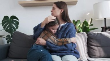 Değer veren genç bir anne, evdeki kanepede oturan hayal kırıklığına uğramış bir çocuğu kucaklıyor. Sevgi dolu bir anne, hayal kırıklığına uğramış mutsuz bir kızın sempatisini destekler. İnsanlar azarladıktan sonra barış yapıyorlar.
