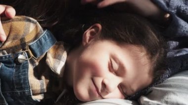 Sevgi dolu annenin ellerine yakın. Evdeki güneşli oturma odasındaki kanepede uzanmış gözleri kapalı mutlu küçük kızını okşa. Aşk, evlatlık çocuk için yeni anne, sıcak ilişkiler, ilgi kavramı
