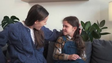 Değer veren mutlu anne selamı küçük kız çocuğuna bir hediye hazırlar kanepeye oturur, birlikte kutlarız. Sevgi dolu genç anne, heyecanlı küçük kızını doğum günü hediyesiyle kutluyor.